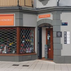 Exterir de la ferretería con fachada gris y letrero naranja